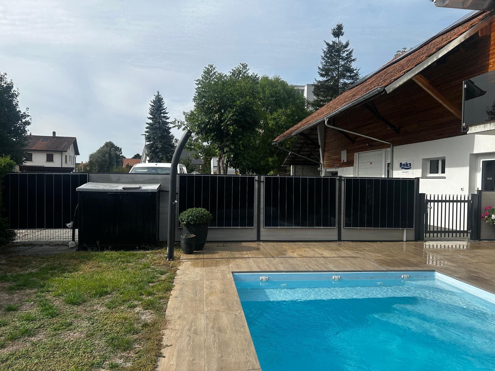 Solar fence of vertically mounted modules around a pool terrace